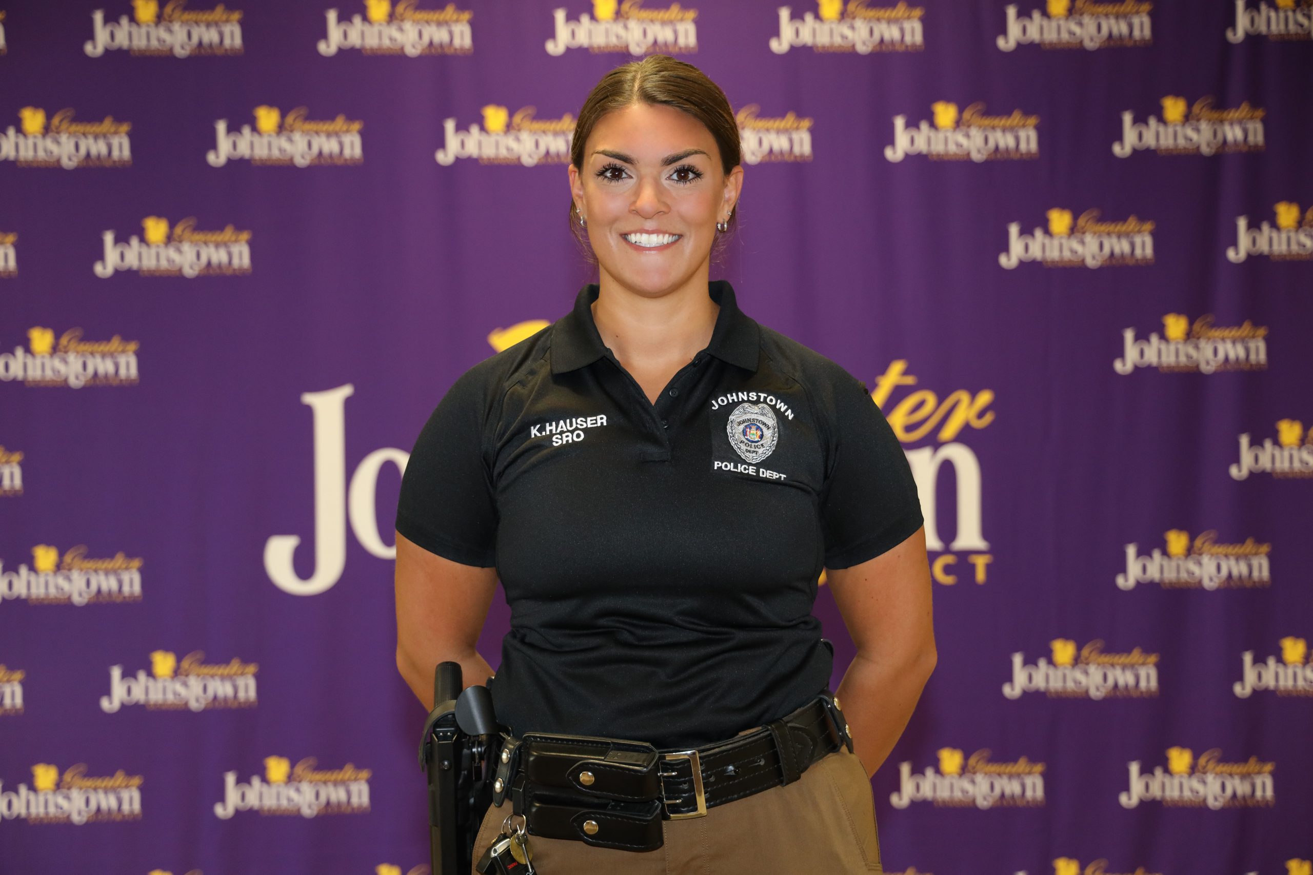 a police officer stands in front of a purple curtain