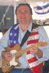 Mr. Aldrich wearing an American flag vest and holding an electric guitar