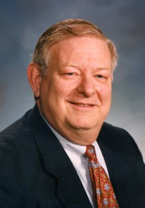 Eric L. Steenburgh portrait wearing dark suit with red tie