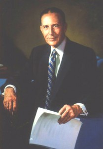 Ted Vosburgh formal portrait wearing a suite and tie holding a document