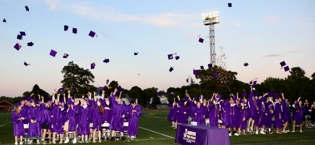 Students throw their caps in the air at a graduation ceremony