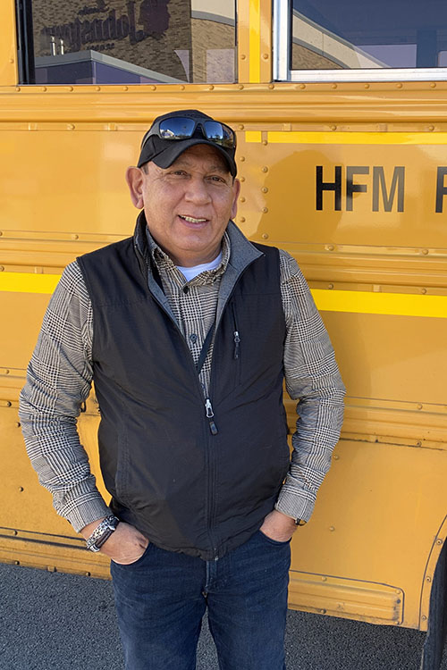 Jose Gonzales stands next to a yellow school bus