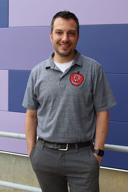 Matt Greco wears a shirt that says "Teacher of all things"