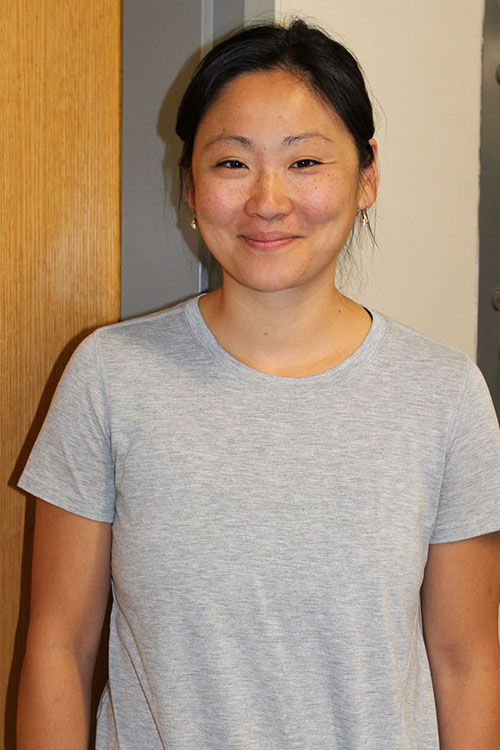 Meghan Oare smiles warmly in front of a classroom door