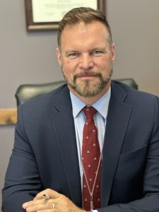 a man in a suit and tie sits in an office at a desk
