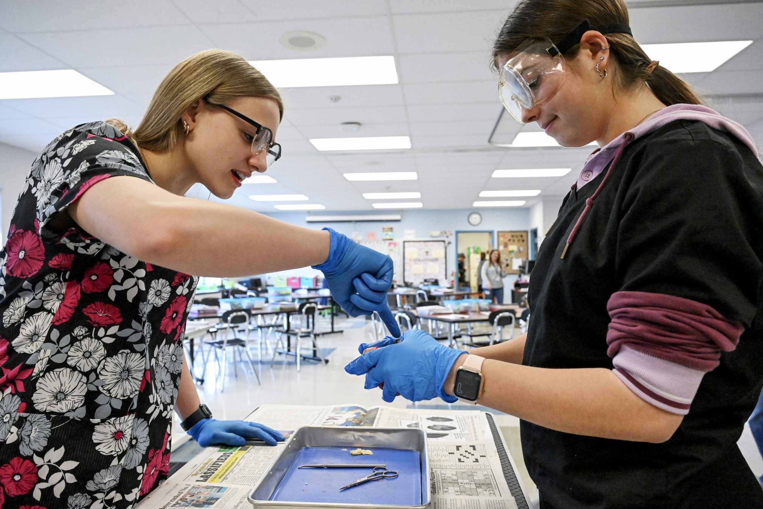 One student points out something of interest held in the hand of another student