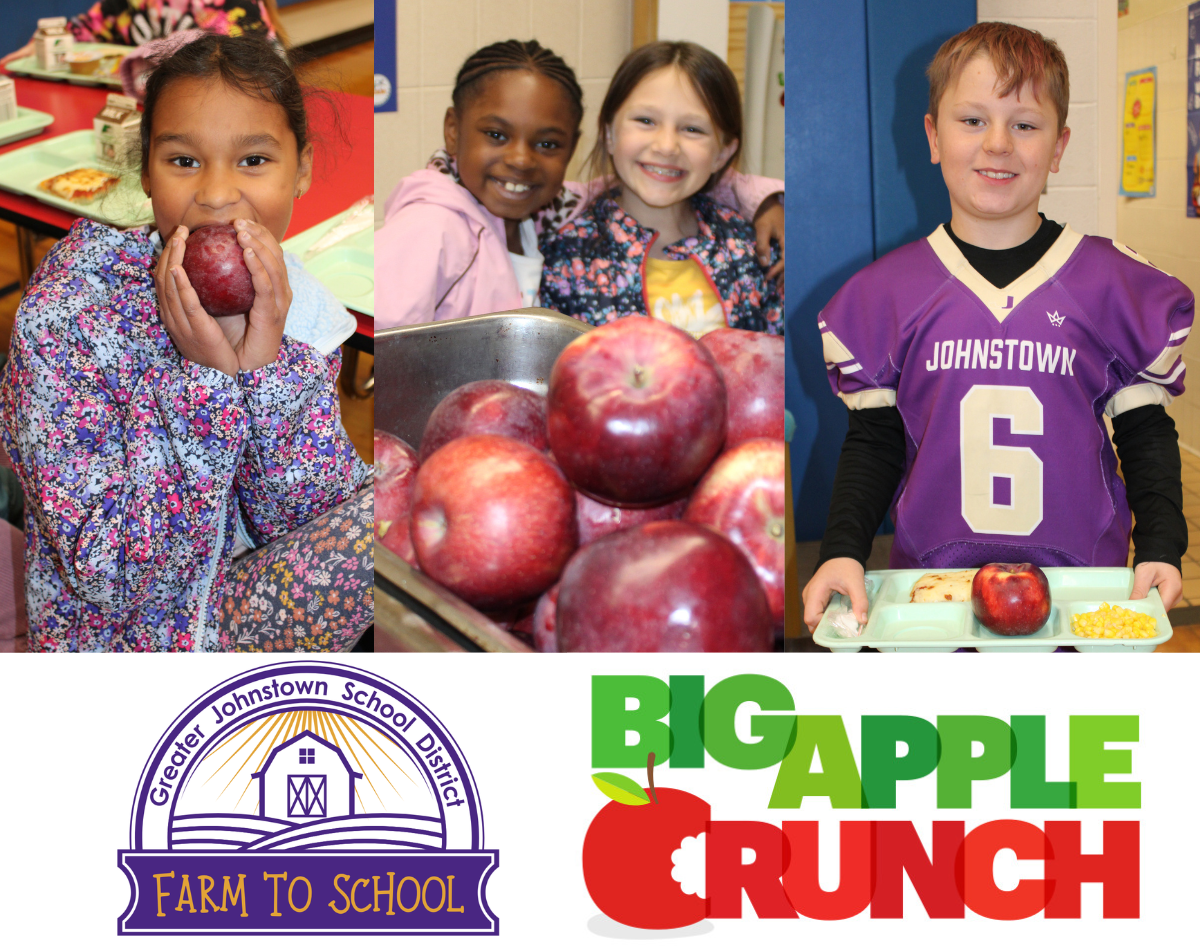 students show off apples that they are eating, with two logos underneath them - one for "Farm To School" and one for "Big Apple Crunch"