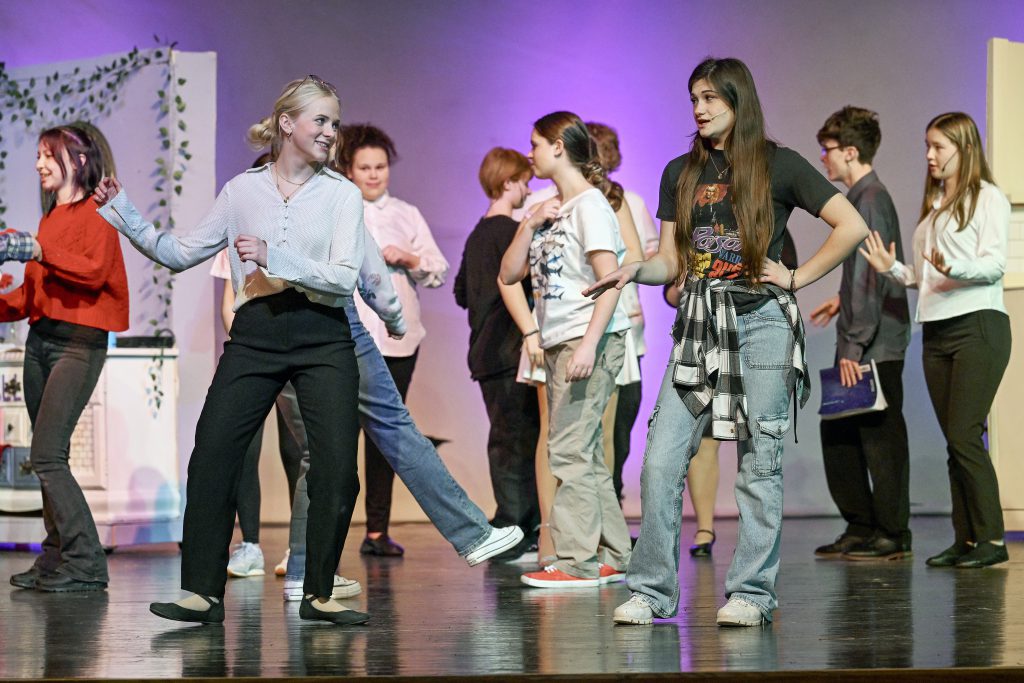 student actors act out a scene on stage